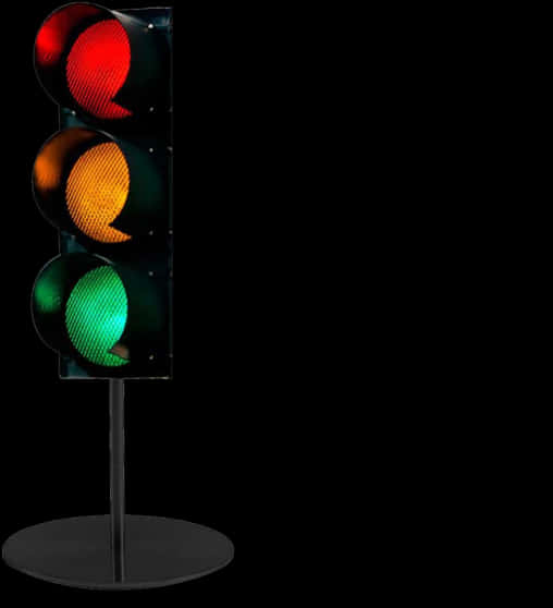 黑色背景上的交通燈 壁紙 — 一個垂直的交通燈，紅色、黃色和綠色的燈光在純黑色背景上發光。