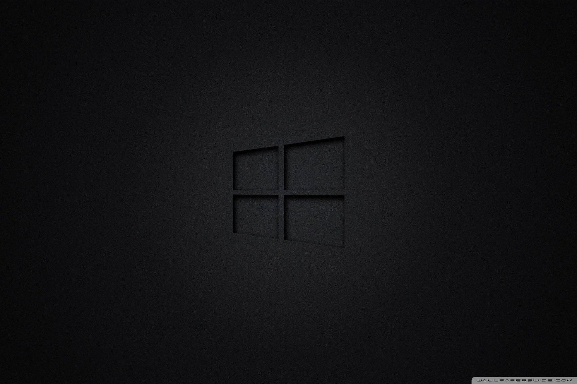 Windows標誌壓印在啞光深色表面上，柔和燈光。