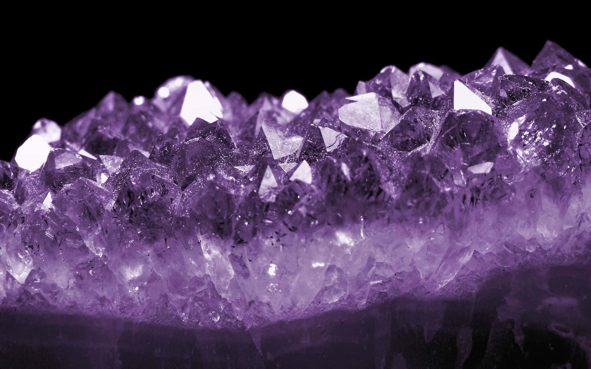 Amethyst 桌布 壁紙 — 黑色背景上閃閃發光的紫色紫水晶晶體的近距離特寫。