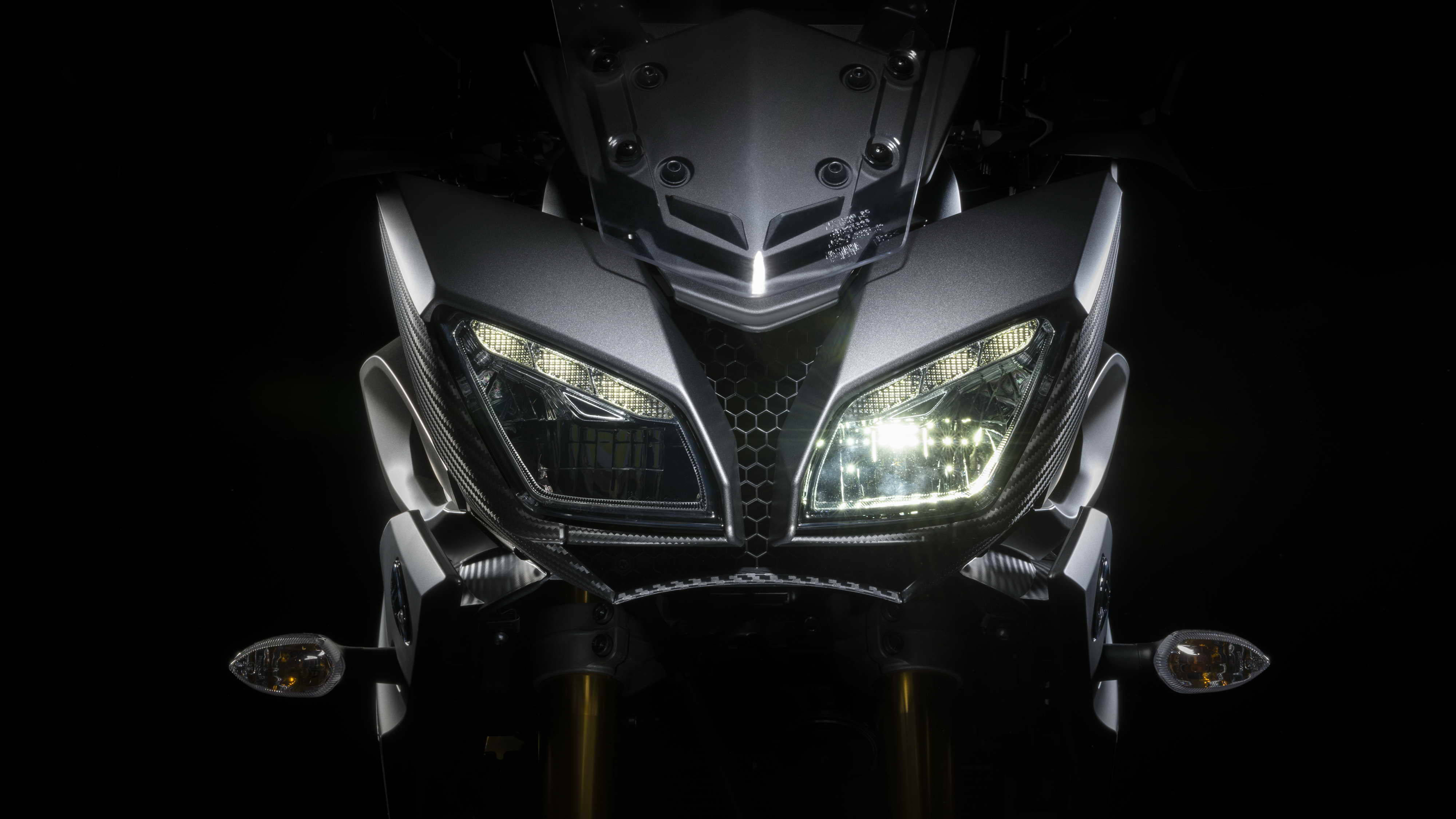 yamaha mt 15 桌布 壁紙 — 黑色背景前，時尚電單車發光車頭燈的特寫。