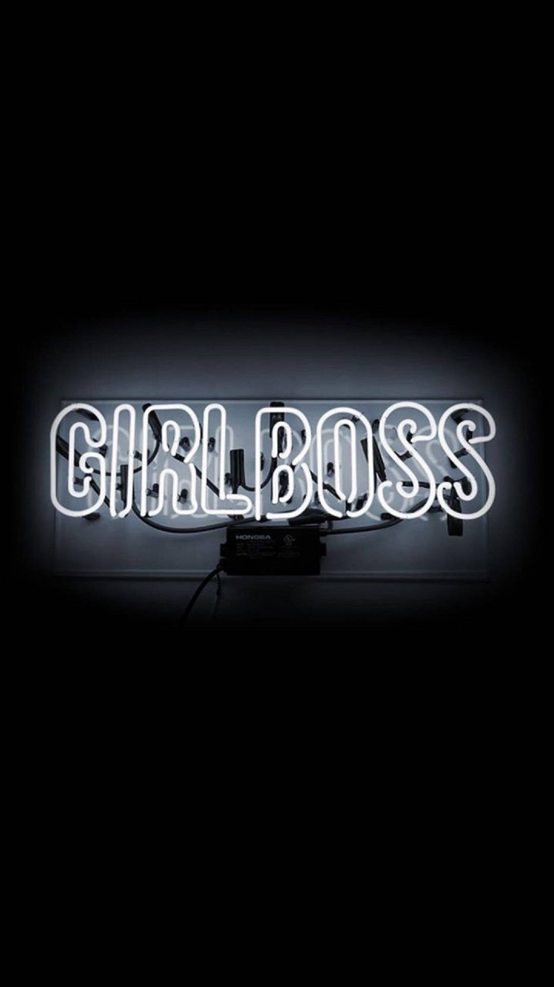 一個明亮的白色霓虹燈牌，在深色背景上顯示「GIRLBOSS」。