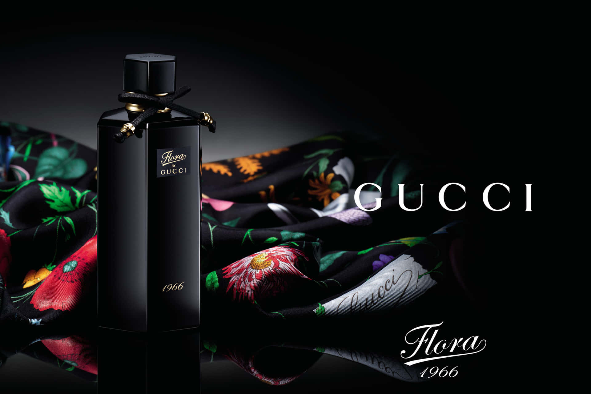 黑色 Gucci Flora 1966 香水瓶與花卉絲巾在反光表面上。