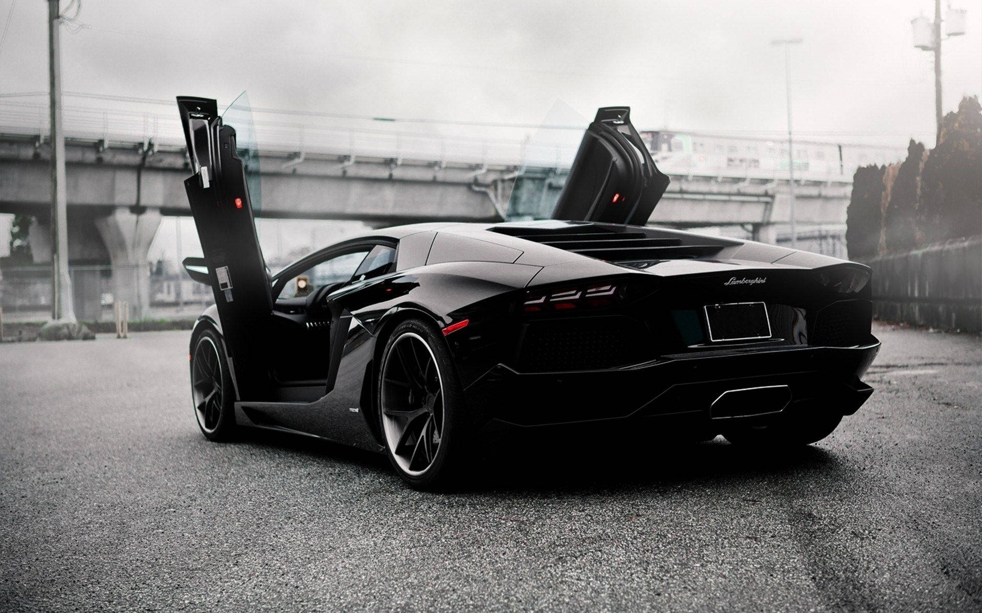黑色林寶堅尼 Aventador 在都市道路上打開鷗翼車門，黃昏時分。