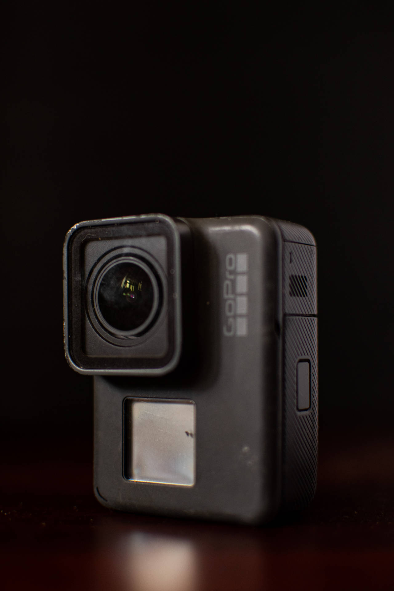 黑色GoPro運動相機在深色木質表面上的特寫。