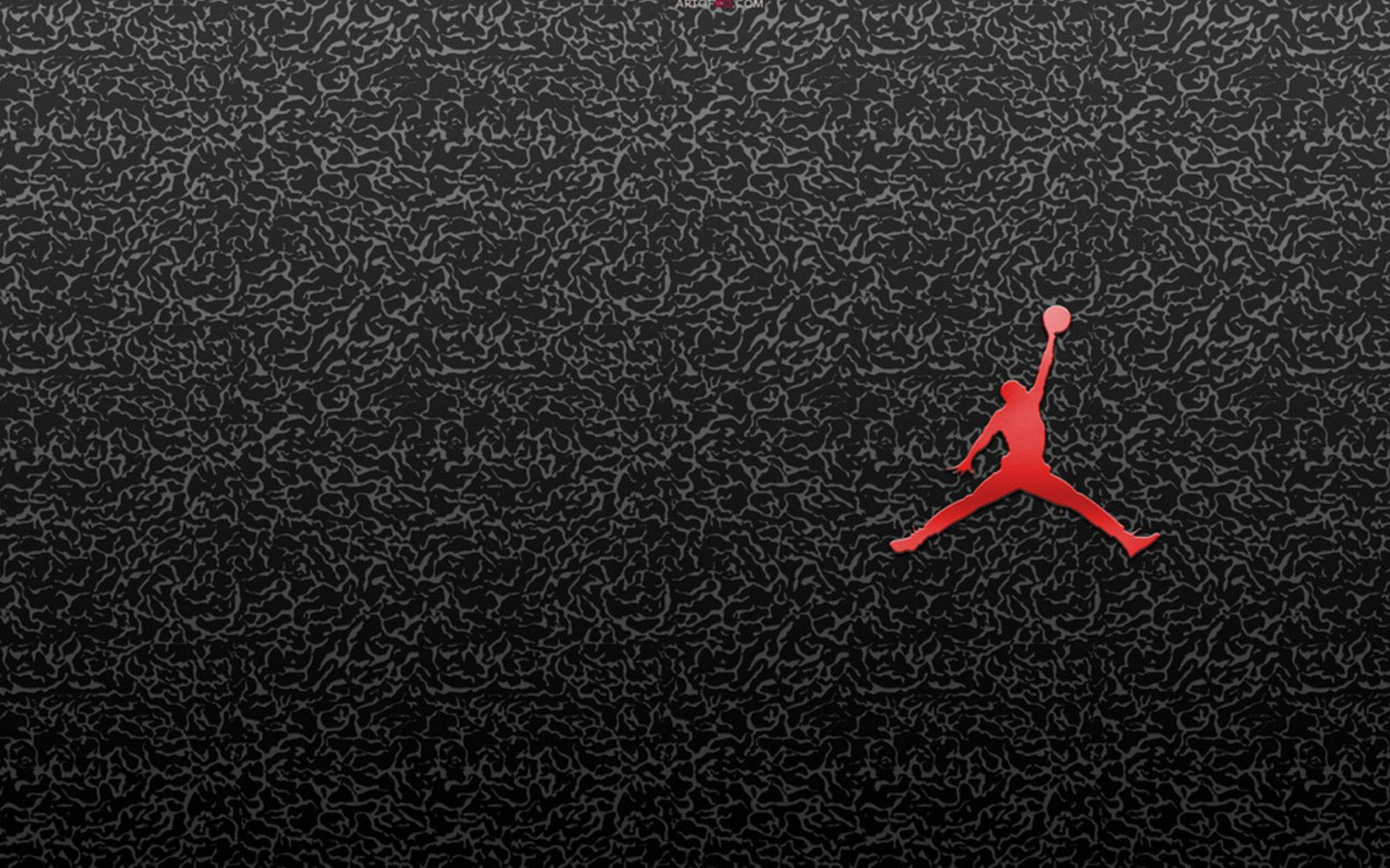 黑色金屬 Air Jordan 壁紙 — 一個大膽的紅色剪影，描繪一名籃球運動員在半空中持球，背景為深色紋理。
