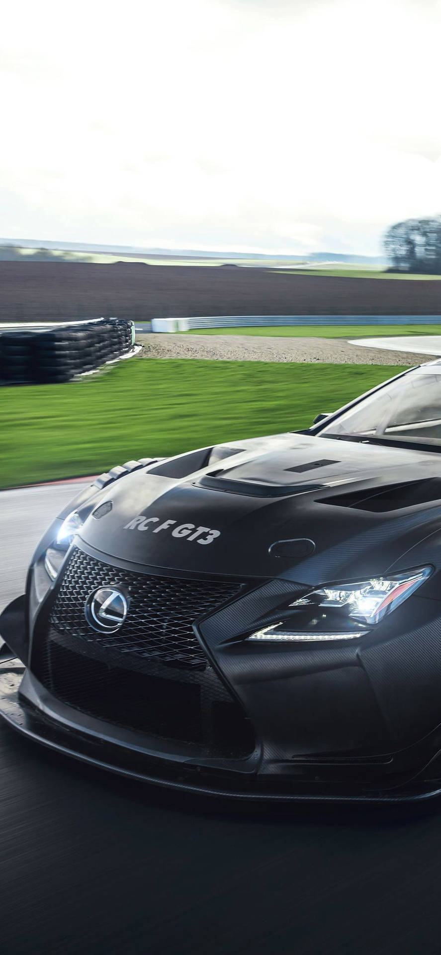 黑色 Lexus RC F GT3 賽車在賽道上飛馳，背景模糊。