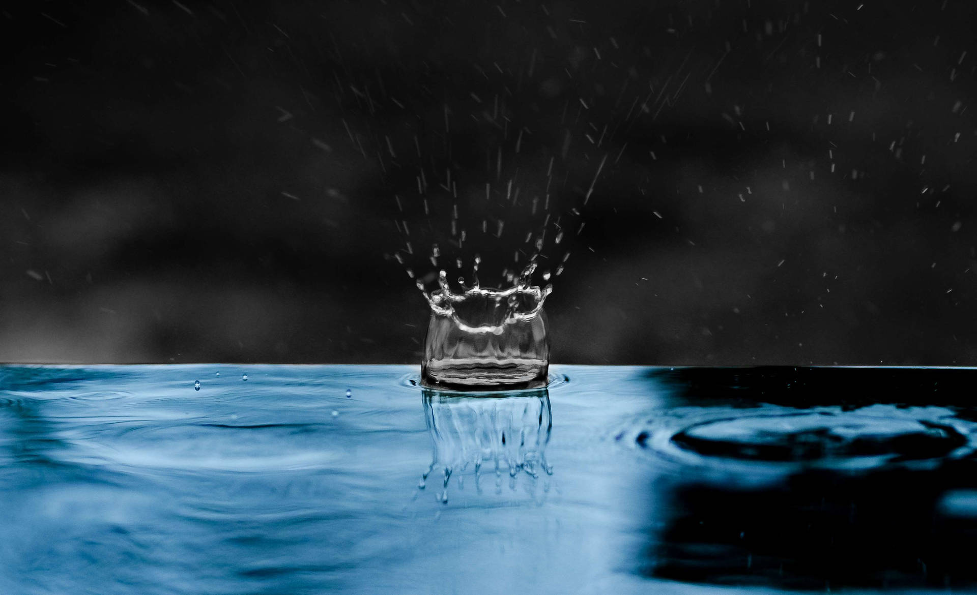 雨點濺落水面，形成水滴和漣漪組成的皇冠。