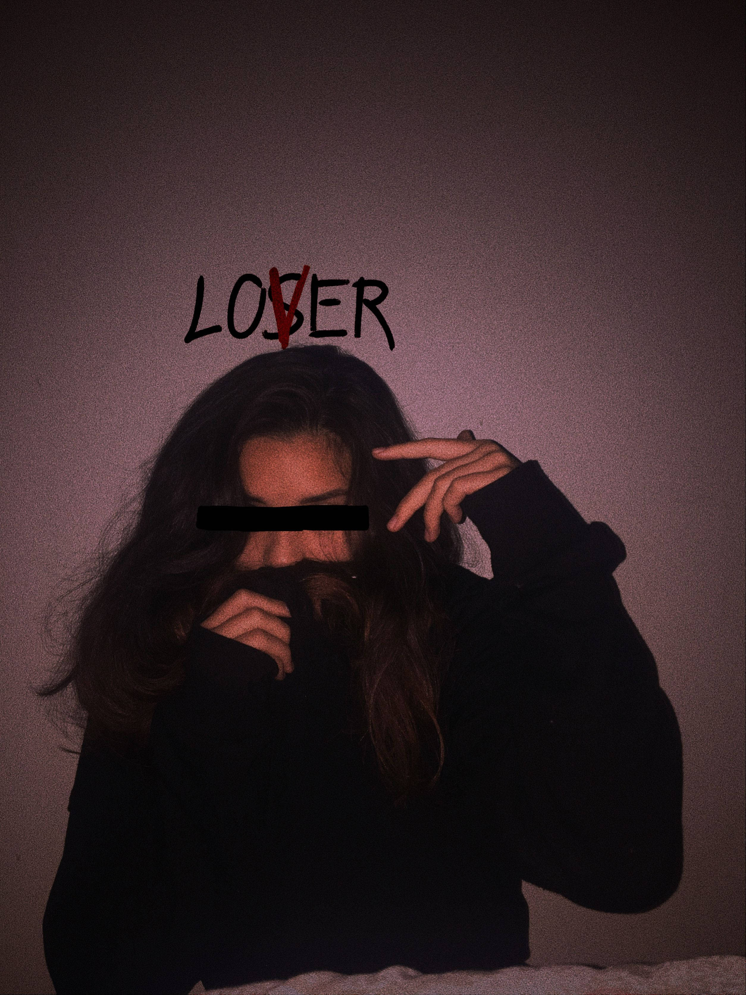 黑衣少女美學個人頭像 壁紙 — 一個穿著深色連帽衫的人隱藏他們的臉，而帶有紅色X的「失敗者」一詞在昏暗的燈光下懸掛在他們上方。