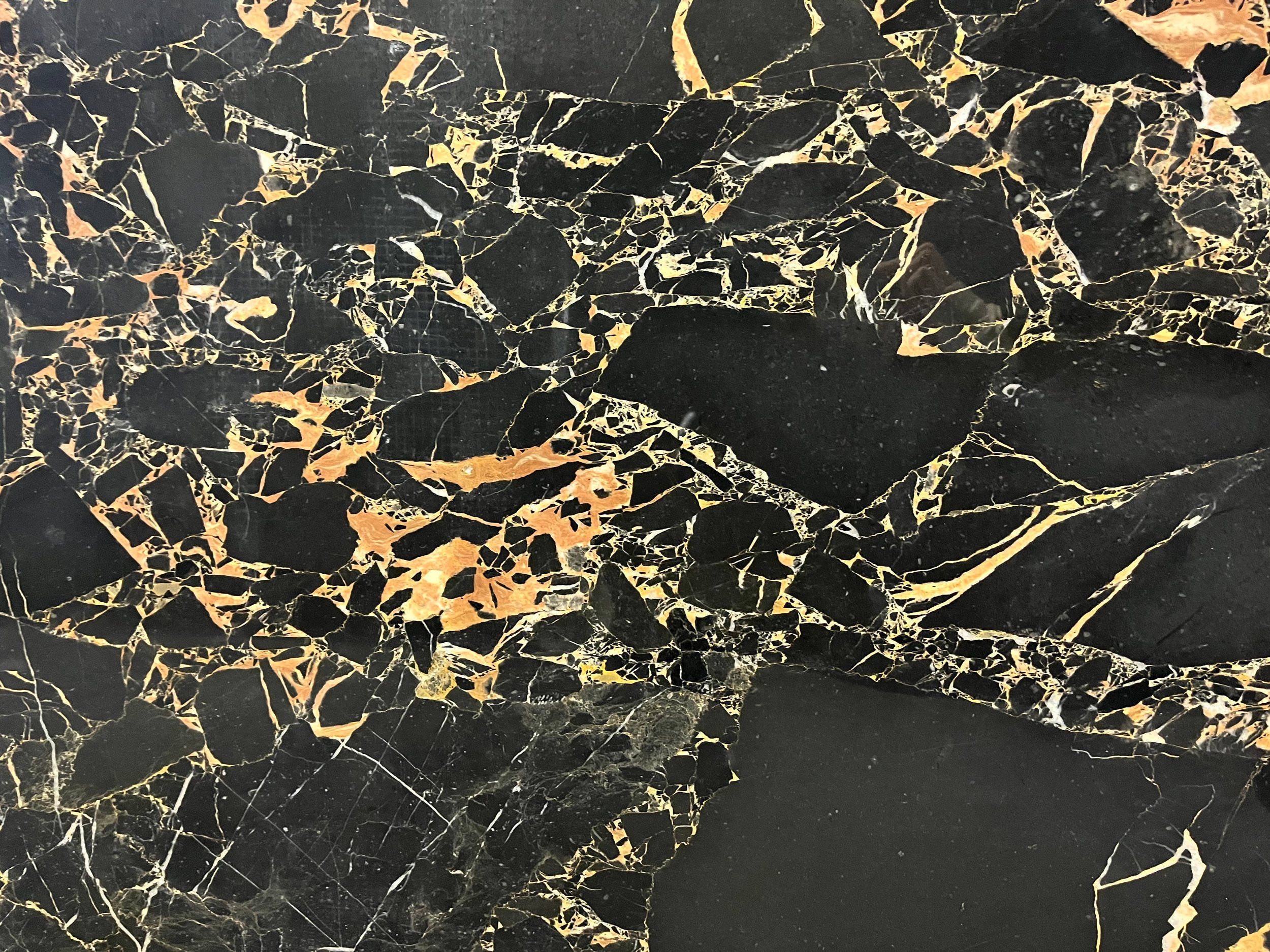 黑金大理石紋理 壁紙 — 奢華的黑色大理石表面，帶有複雜的金色紋理和溫暖的琥珀色點綴，營造出大膽華麗的圖案。