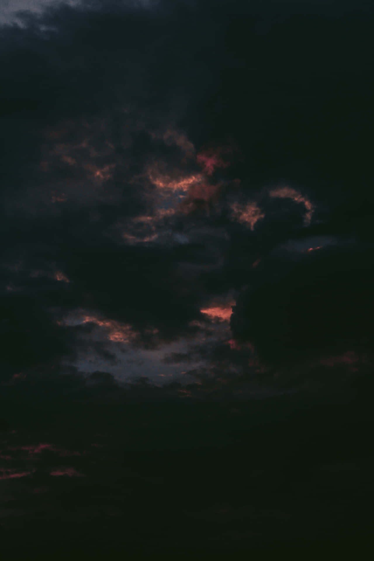 暮色中被火熱的橙色和紅色照亮的暗雲。