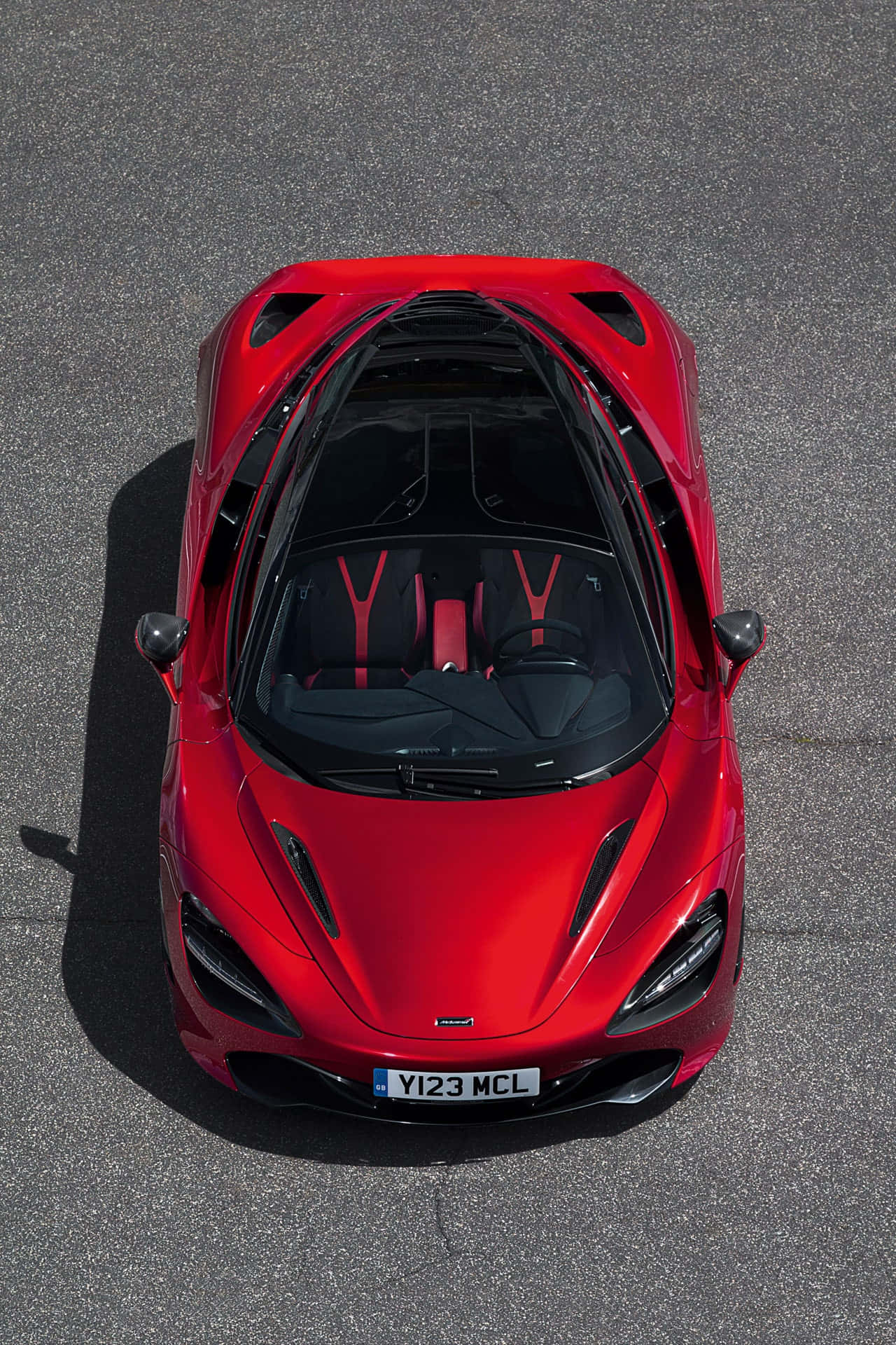 從瀝青上方俯瞰紅色McLaren跑車。