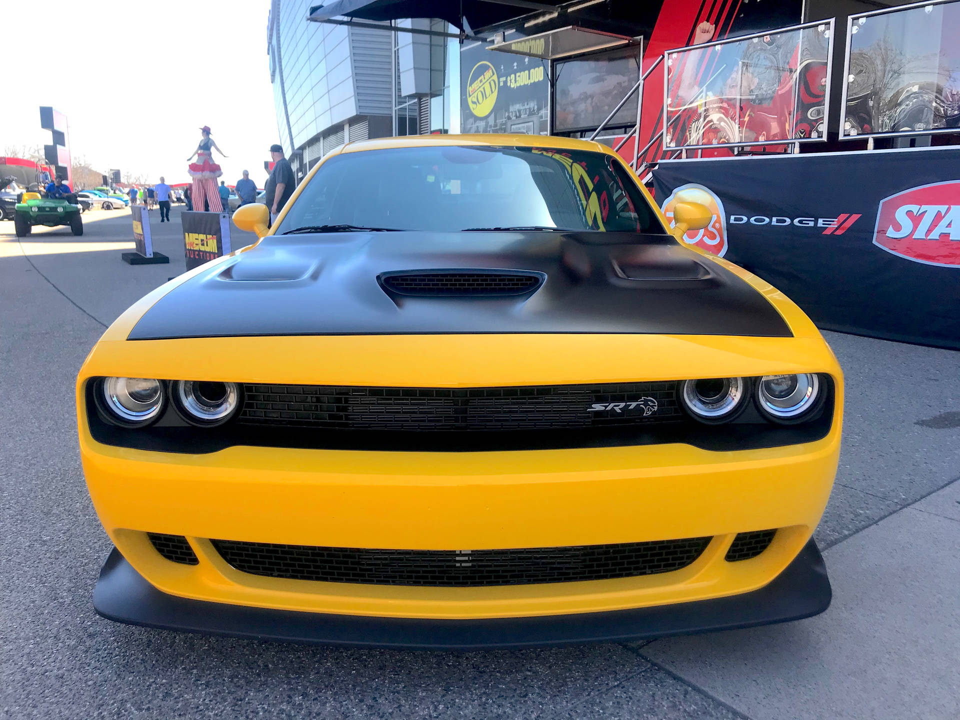 黃色道奇挑戰者SRT在車展上，背景有人群和橫幅。 — Dodge challenger GIF 壁紙