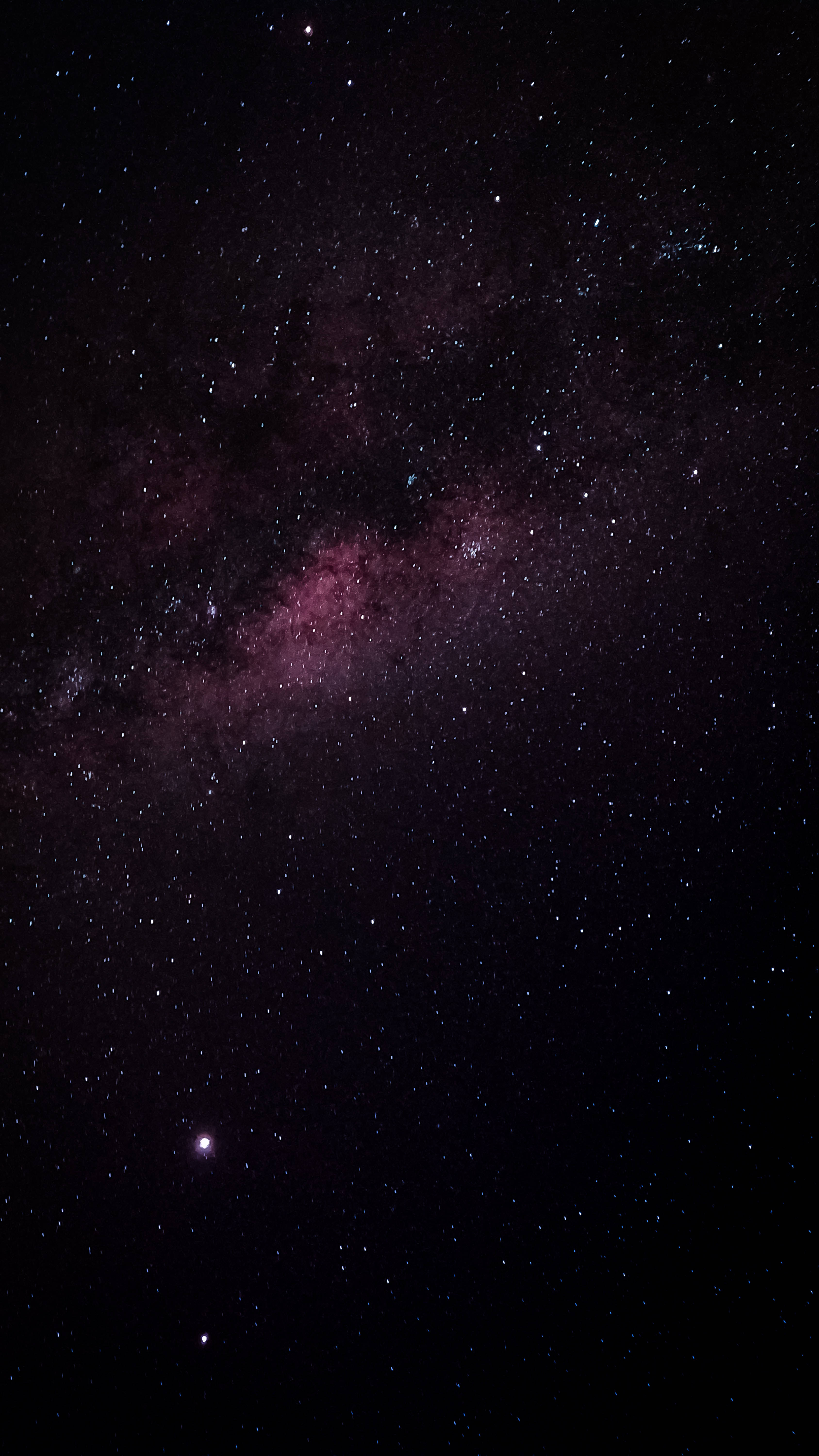 黯淡粉紅星系 壁紙 — 令人嘆為觀止的銀河系景觀，粉紅色和紫色的星雲在深邃的黑色天空中閃耀，充滿無數星星。