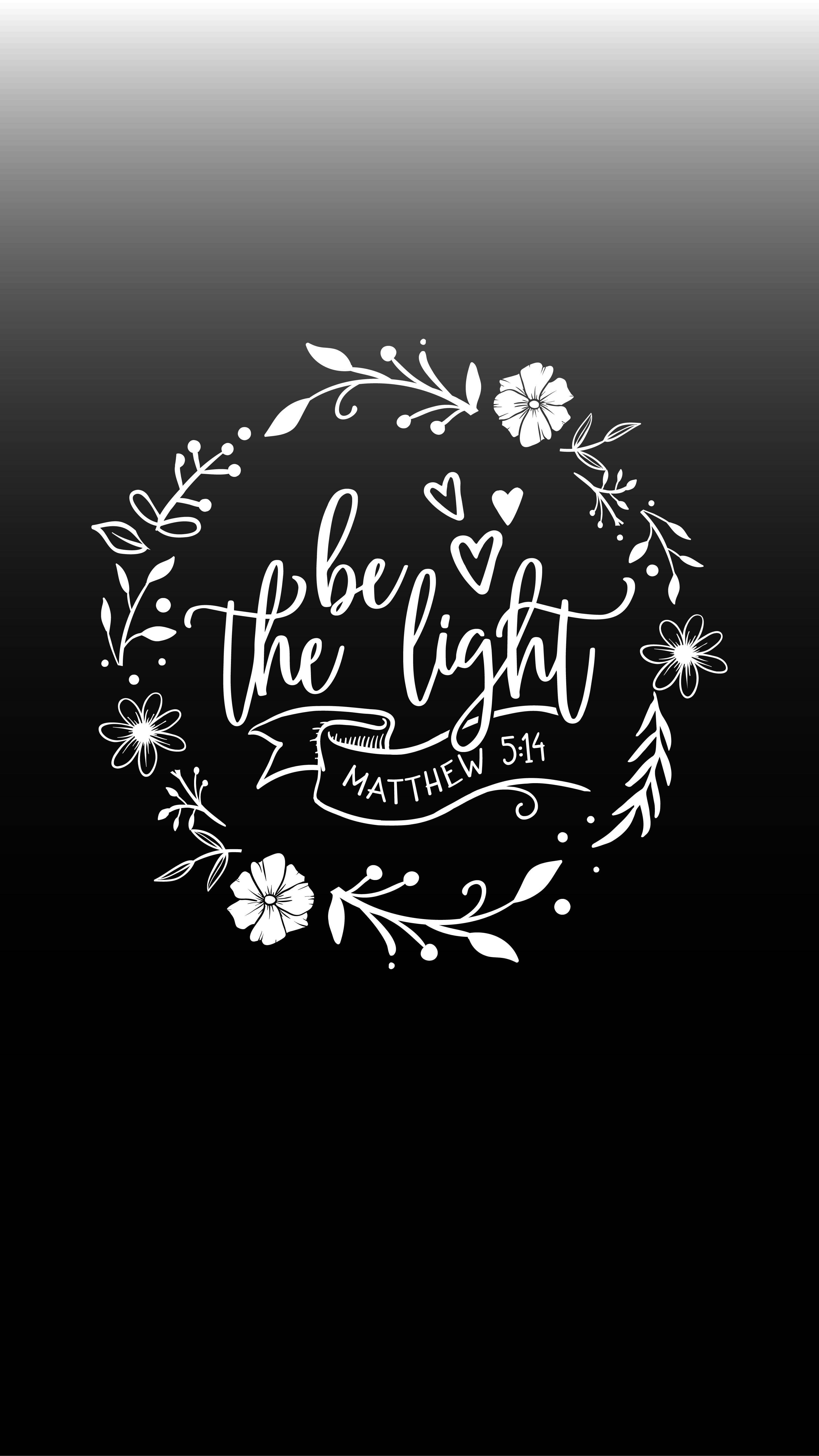 鼓舞經文：「做光」 壁紙 — 白色花環，中央有草書文字 be the light 和馬太福音 5:14，位於黑色漸變背景上。