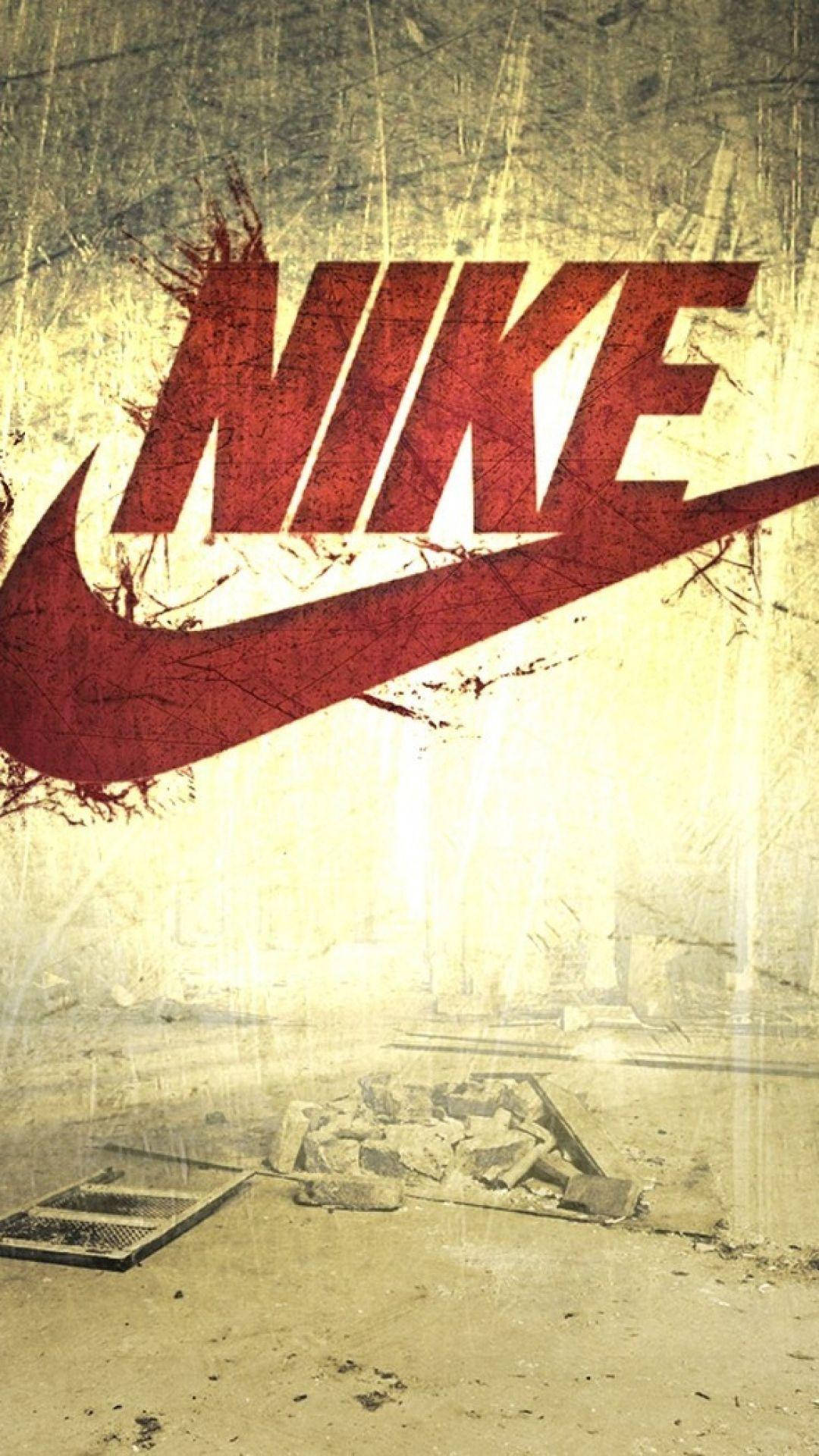 龐克風耐克iPhone壁紙 壁紙 — 一個風化的紅色Nike標誌主導著一個粗糙的城市衰敗場景，有破碎的混凝土和碎片。