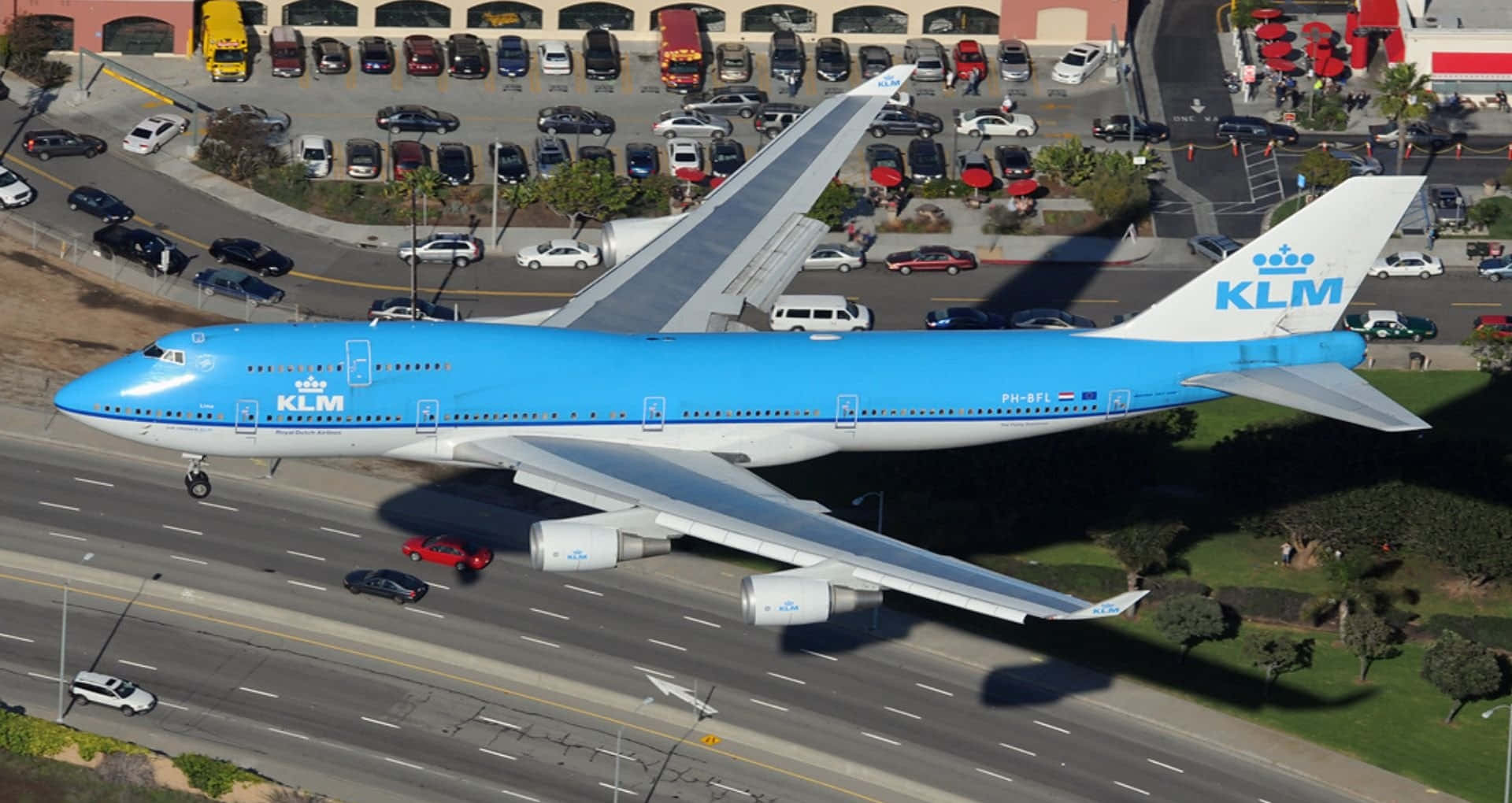 KLM波音747在高速公路和停車場上空低飛。