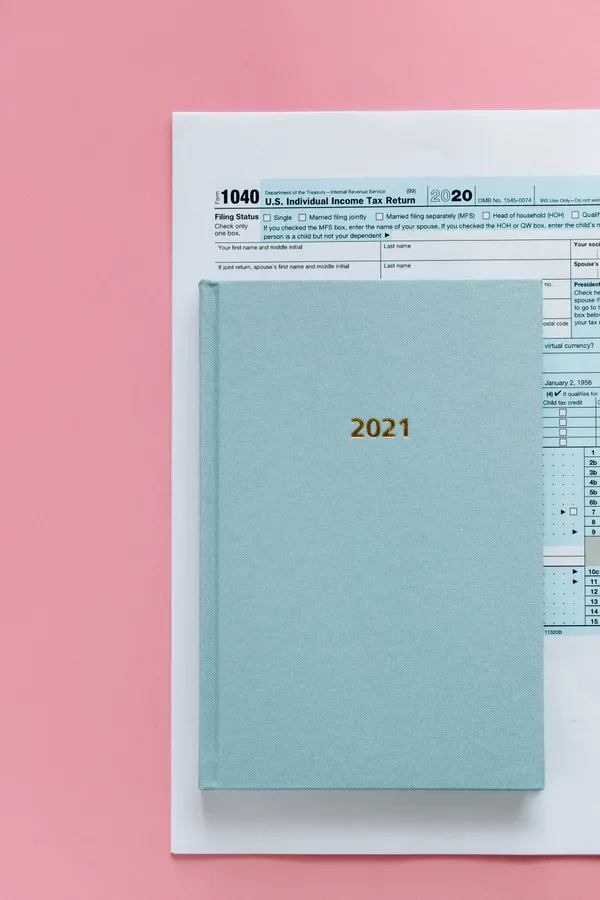 藍色文件夾標有2021,放在2020年稅表上,背景為粉紅色。