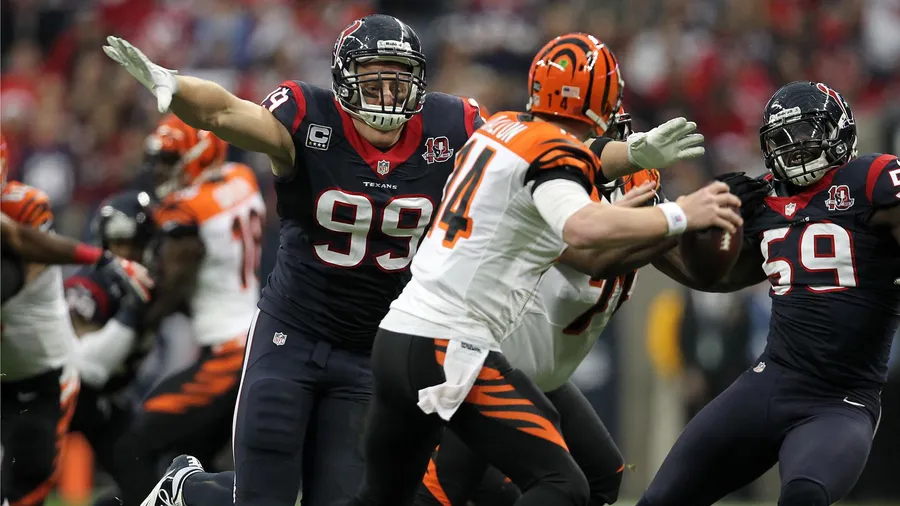 NFL美式足球運動員在比賽中行動,防守球員擒抱四分衛。