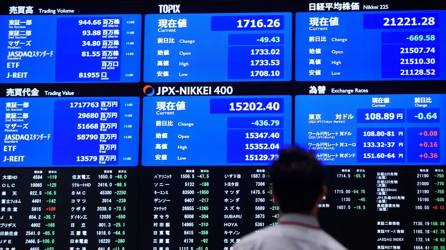 交易員在東京證券交易所走過金融數據屏幕。