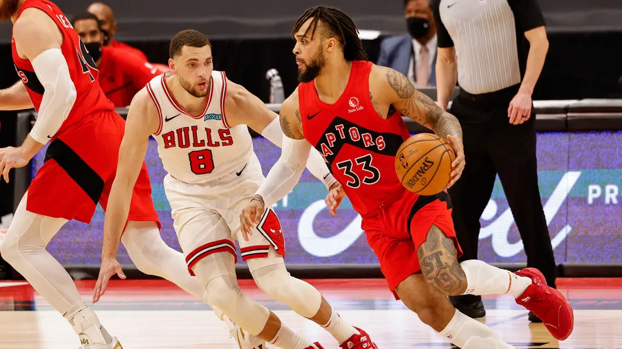 多倫多速龍球員在NBA比賽中運球越過芝加哥公牛防守球員。