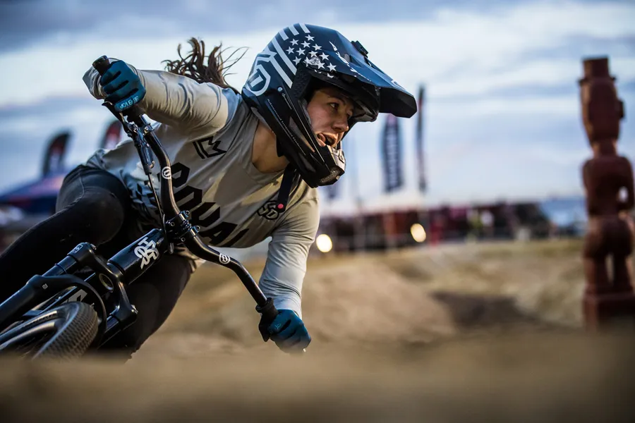 女BMX車手在泥地賽道上傾身過彎。