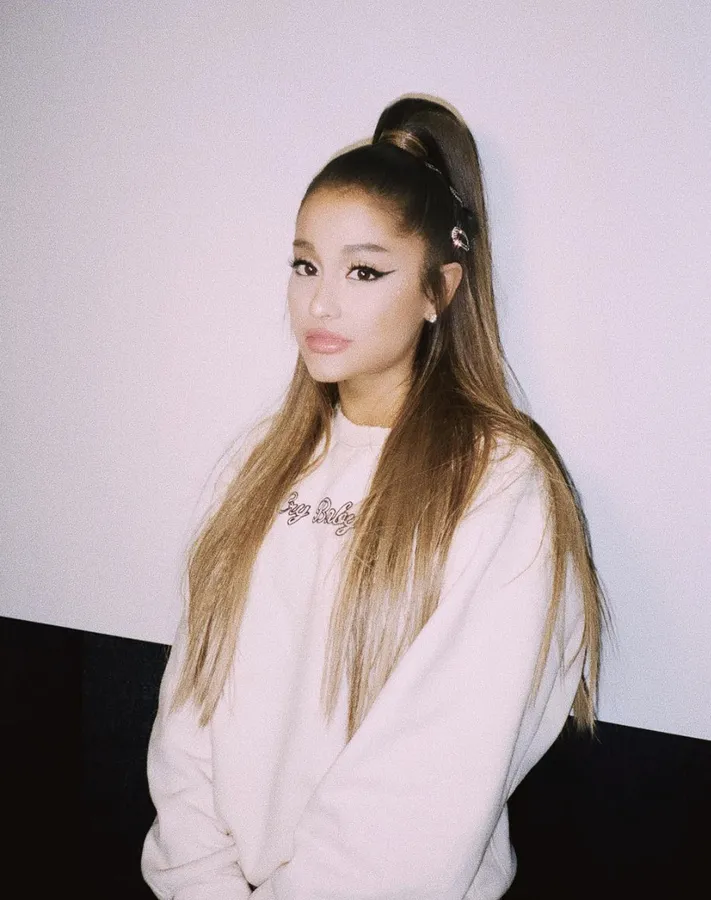 Ariana Grande 身穿白色衛衣,頭髮紮成高馬尾。