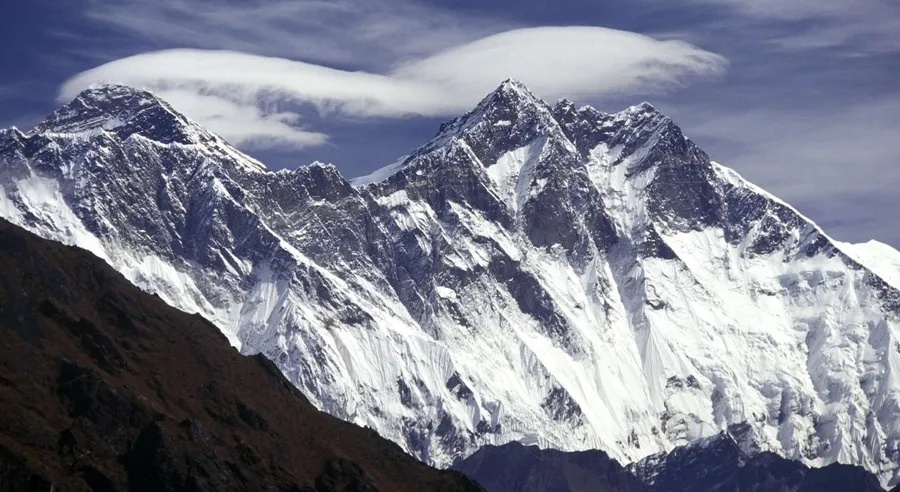 積雪的山脈,岩石斜坡上有透鏡狀雲