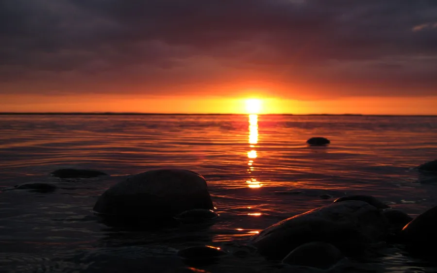 水面上的夕陽,前景岩石投下陰影