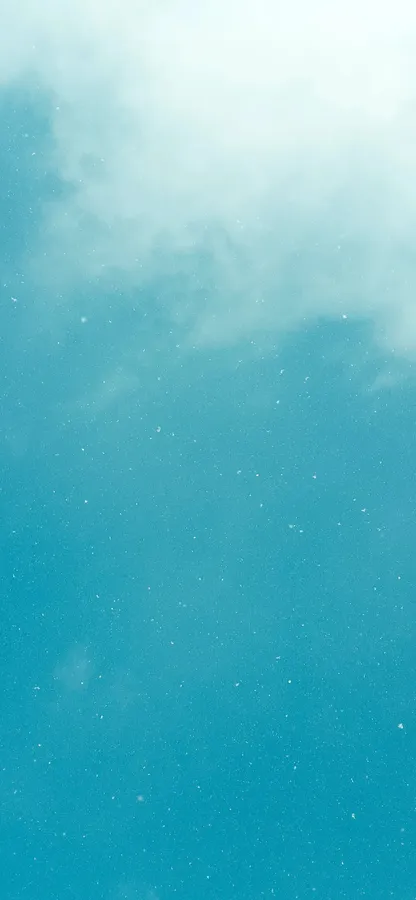 平靜的藍綠色天空,帶有柔和雲朵和散落的光點
