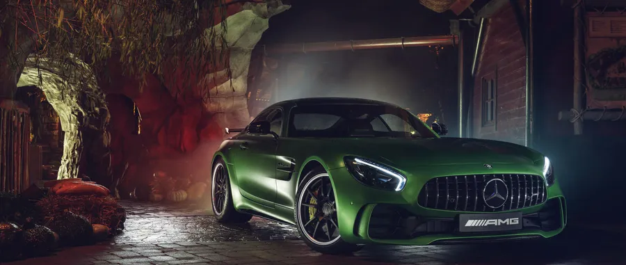 綠色 Mercedes-AMG GT 跑車在黑暗有霧的車庫中,帶有戲劇性的燈光。