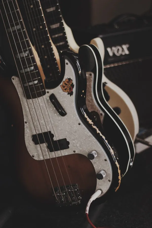 在昏暗的錄音室中,磨損的復古低音結他與Vox擴音器。