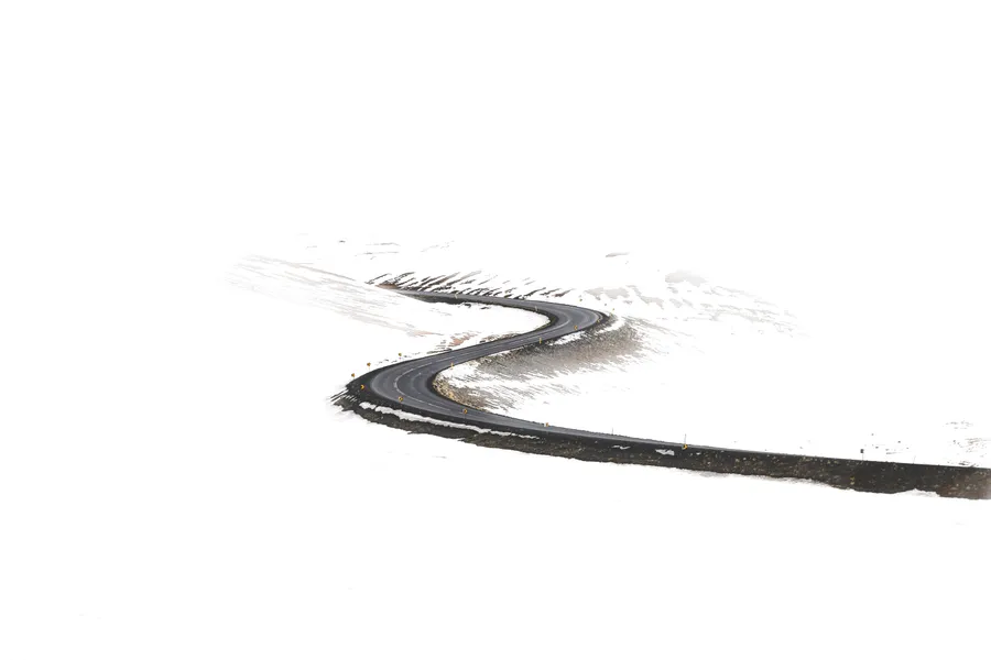 冬季穿過雪山蜿蜒的道路
