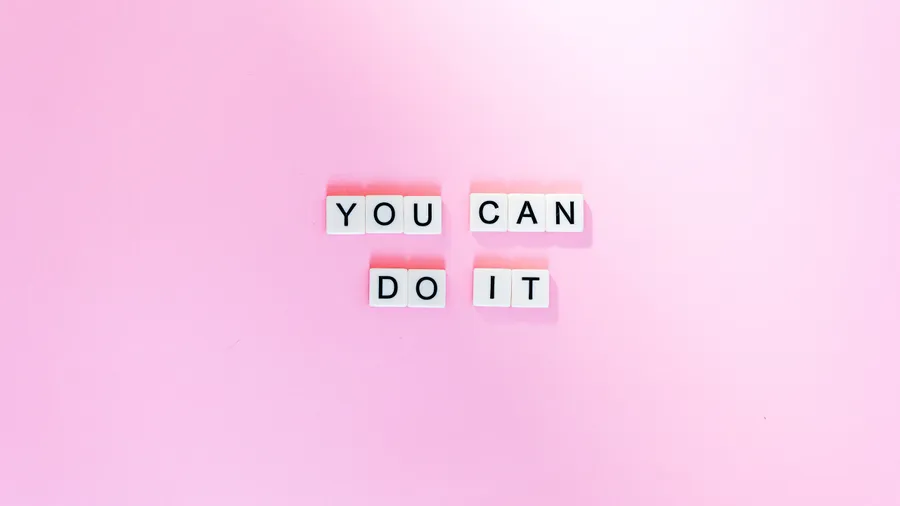 在粉紅色背景上用白色字母瓷磚拼出的勵志短語 you can do it。