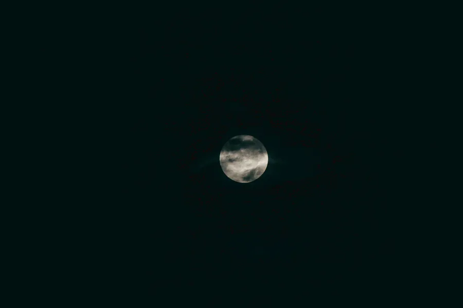 在黑暗的夜空中,月亮被雲層部分遮蓋。