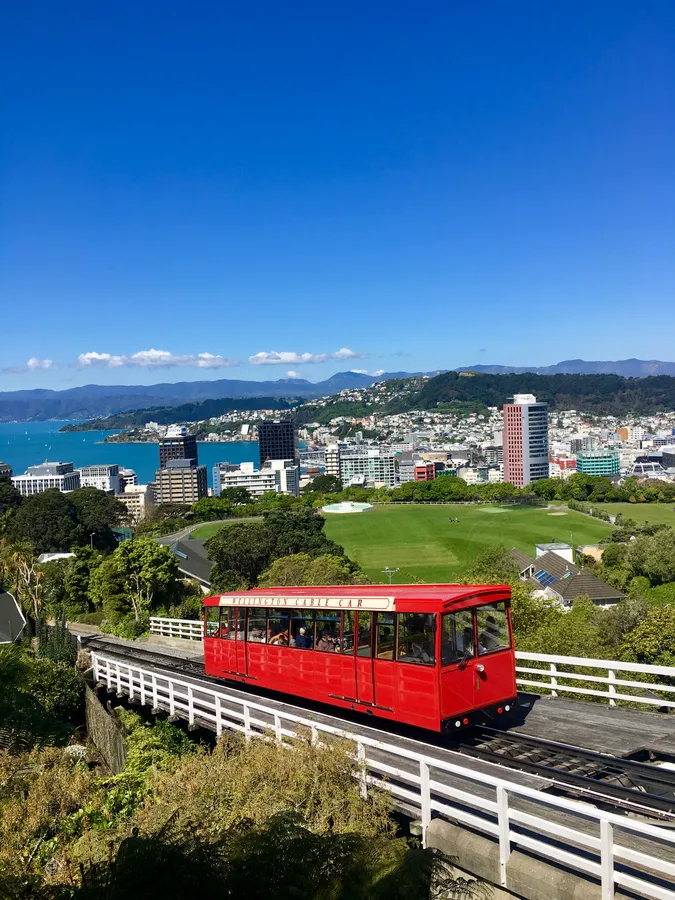 紅色纜車在高架軌道上,城市與海洋景觀