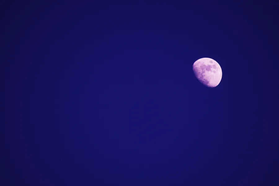 在深藍色夜空中發光的紫色月亮。