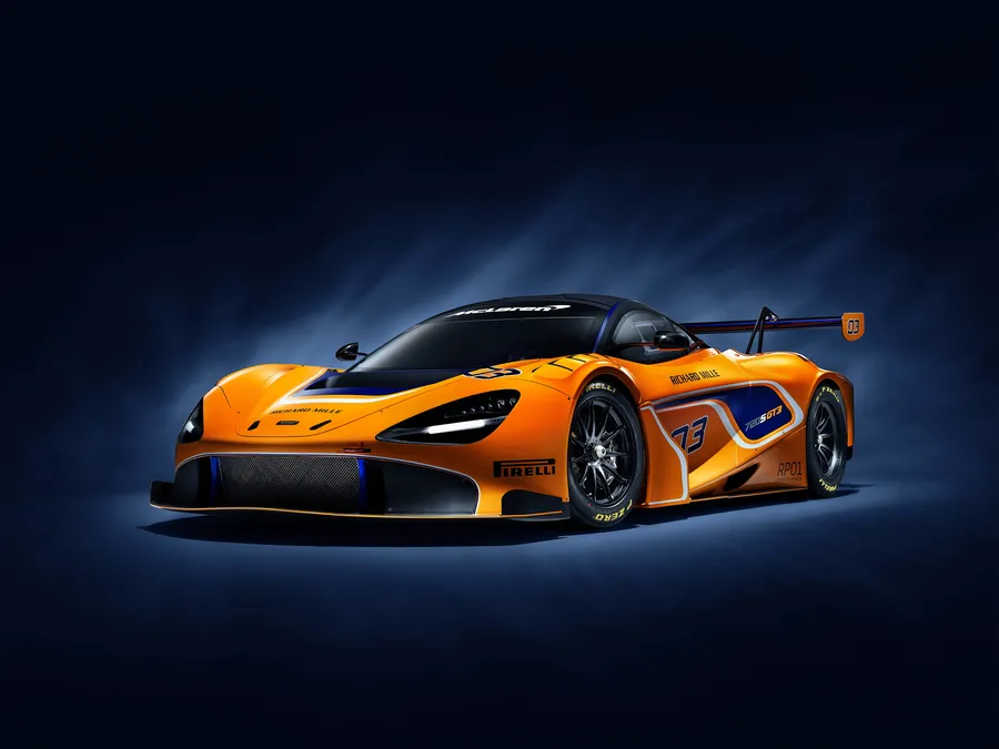 橙色McLaren SRT賽車,帶有藍色點綴和73號,在工作室燈光下。