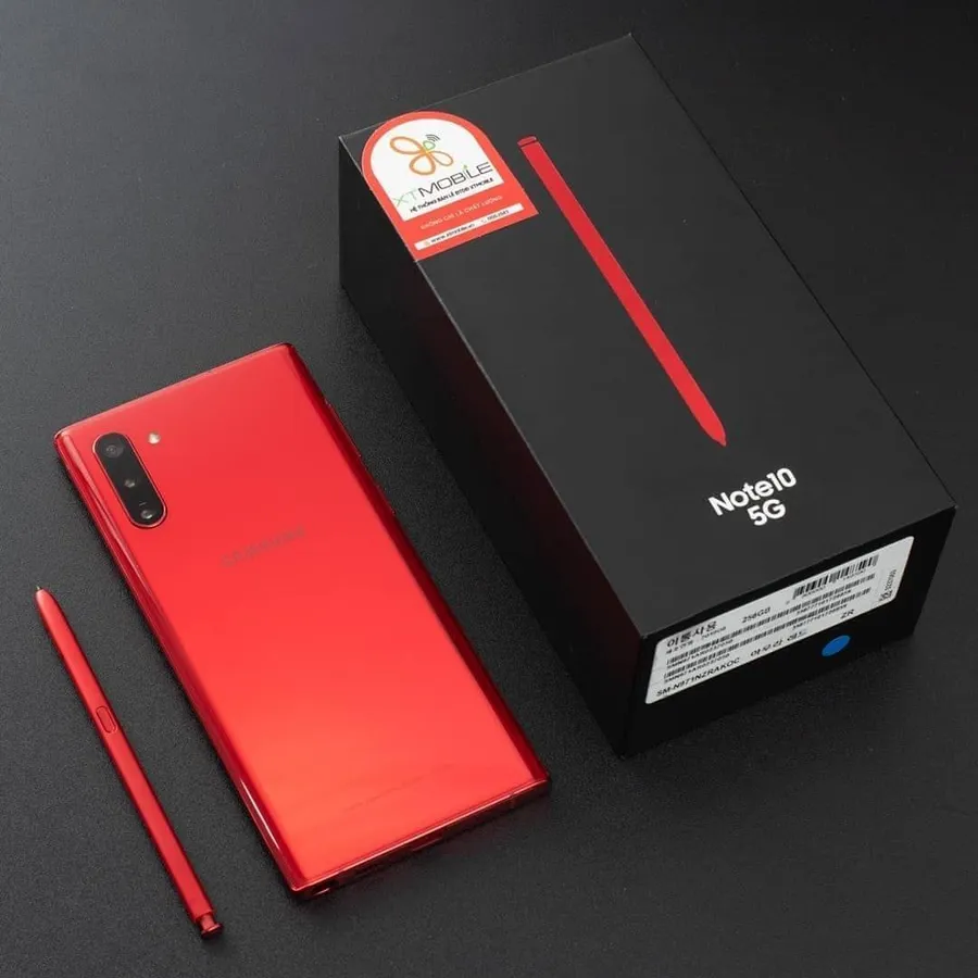 深色表面上帶有S Pen和盒子的紅色Samsung Note10 5G手機。
