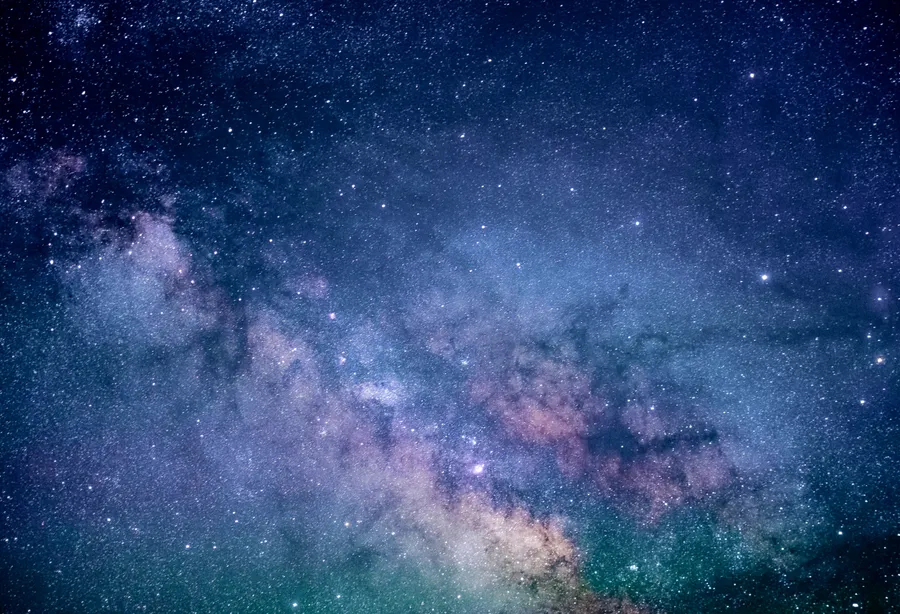 在深藍色夜空中閃耀著宇宙塵埃和星辰的銀河系。