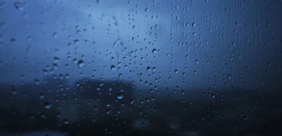 窗戶上的雨滴,俯瞰夜晚的黑暗城市。
