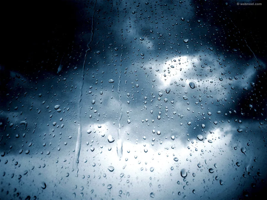 窗戶上的雨滴顯示多雲的天空