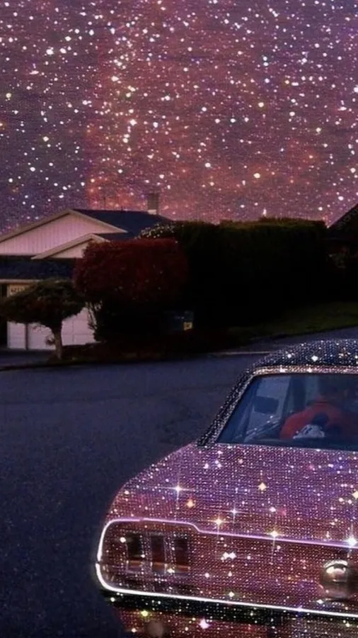 在寧靜社區的星空夜空下,一輛閃閃發光的紫色汽車。