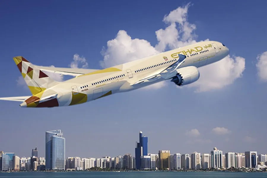 阿提哈德航空飛機飛越擁有摩天大樓和水域的現代城市。