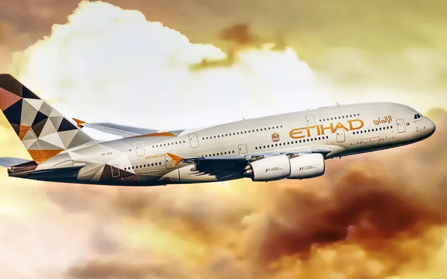 阿提哈德航空A380飛機飛過金色的日落雲層。