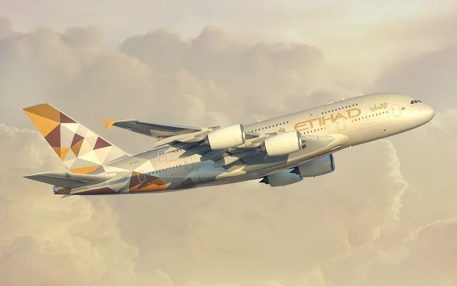 阿提哈德航空A380在日落時飛越金色雲層。