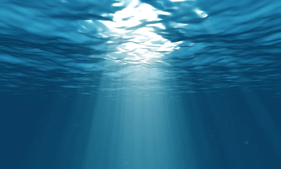 陽光穿過海面照射到深藍色海水中。