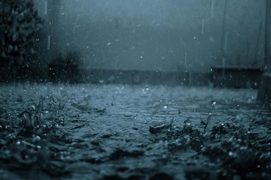 暴風雨天氣中雨滴濺在潮濕的路面上。