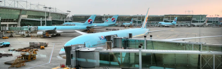 大韓航空飛機在黃昏時停靠在機場閘口。