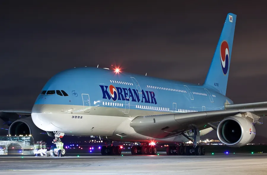 夜間機場停機坪上的大韓航空空中巴士A380與明亮燈光。