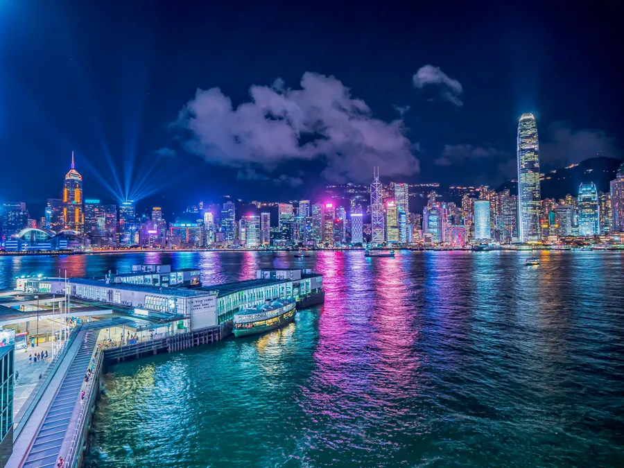香港夜晚的天際線,色彩繽紛的燈光倒映在水面上。
